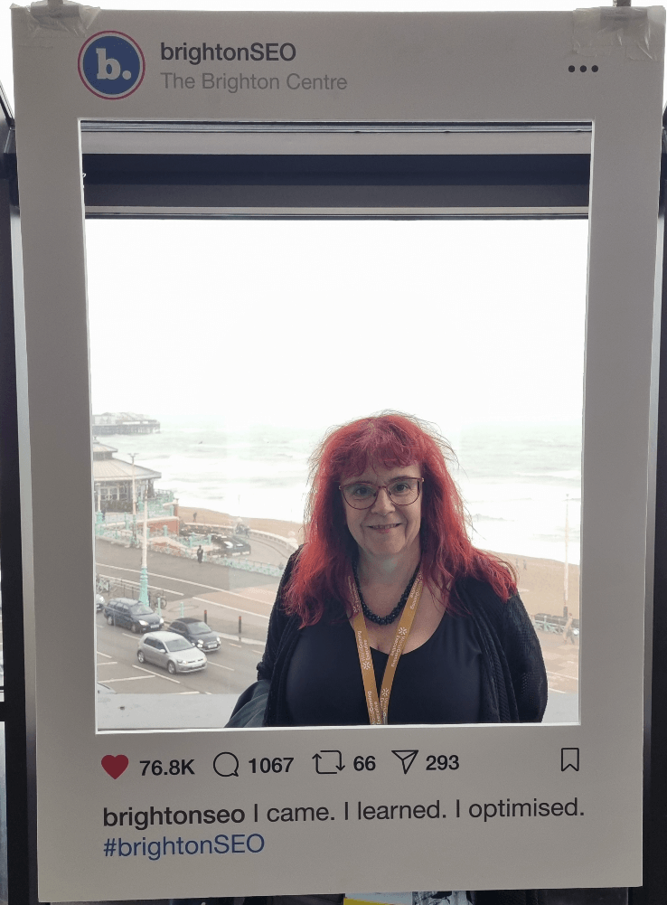 Sue Dawson of FTD Digital stands in a frame that's a mock up of an Instagram post by Brighton SEO, at the Brighton Centre.
